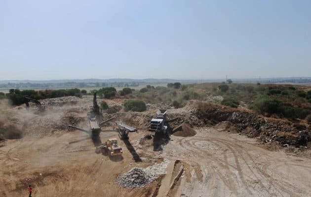 אתר בנייה עם משאיות ומשאיות מזבלה.