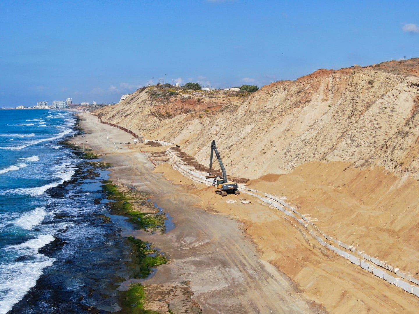 מבט אווירי של דיונת חול בחוף תל ברוך בעבודות הקמת חיזוק המדרון ובניית קיר הים.